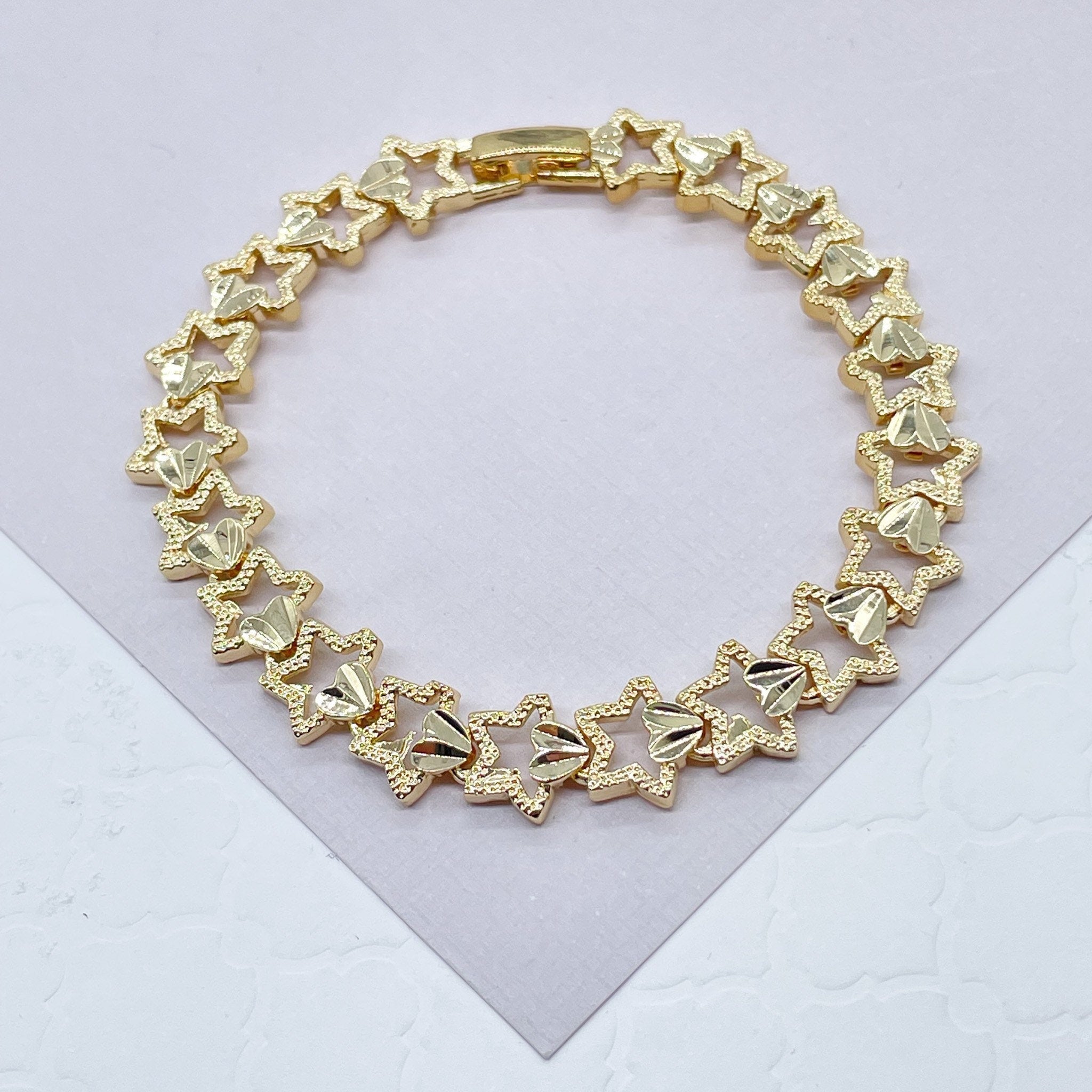 Elegant gold bracelet with intricate patterns on a dark background. -  indivstock